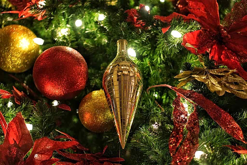 Close-up of gold and red Christmas ornaments with lights
