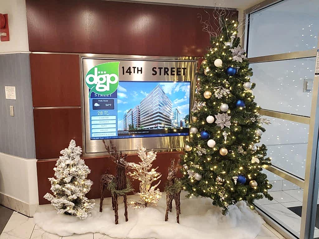 Decorated Christmas tree with reindeer and gifts in an office lobby