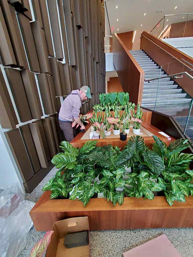 Tiered interior planters with greenery and spring tulips beside a staircase